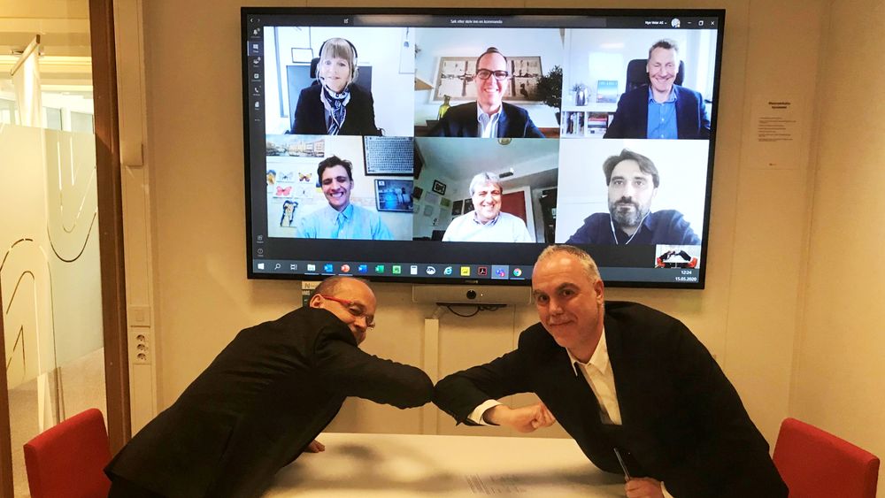 Digital signering med alternativt håndtrykk. F.v: Prosjektdirektør i Nye Veier, Johan Arnt Vatnan, og Pablo García Caramés, finansdirektør for Norge i Acciona. I bakgrunnen ser vi flere fra ledelsen til de to selskapene. Anette Aanesland, adm. dir. i Nye Veier er oppe til venstre i skjermen.