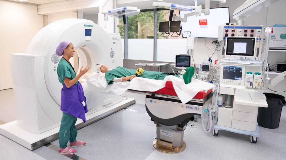 Fagradiograf Margrethe Rasmussen jobber med CT-undersøkelser på Intervensjonssenteret på Rikshospitalet. På bordet ligger reporter Tuva Strøm Johannessen.