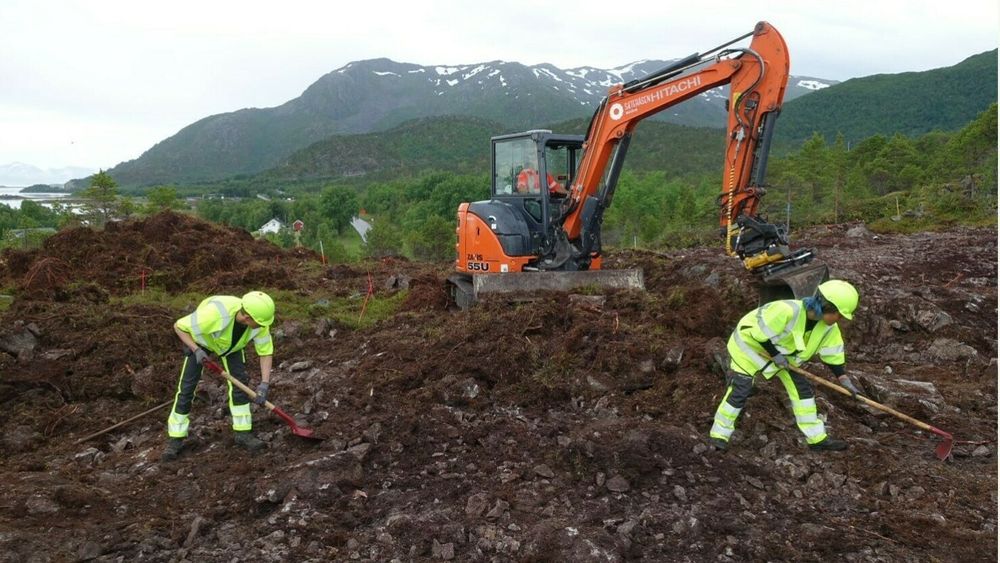 Arkeologer graver ikke bare med skje. Bildet viser avtorving med maskin og krafse på Kåringsklubben. Avtorving er fysisk tungt arbeid for arkeologene, og krevende presisjonsarbeid for maskinførerne.