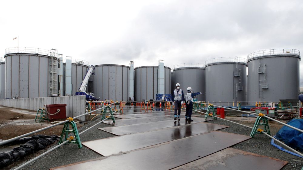 Arbeidere på kjernekraftverket Fukushima Daiichi, som eies av Tokyo Electric Power. Arbeidet med å avvikle det ødelagte atomkraftverket pågår. I bakgrunnen står tankene med radioaktivt vann.