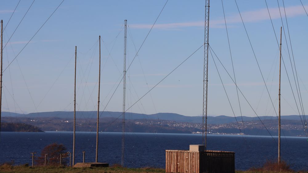 Jeløy Radio ble lagt ned som sendestasjon i 1995. Fortsatt står de fleste av mastene og kablene igjen, som et minnesmerke over den tidligere aktiviteten på stedet. I bakgrunnen, på den andre siden av Oslofjorden, kan man skimte Holmestrand.