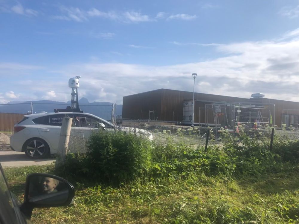 Vinket til fotografen: Apple-bilen passerer her Ibestad sykehjem på øya Rolla sør i Troms og Finnmark.
