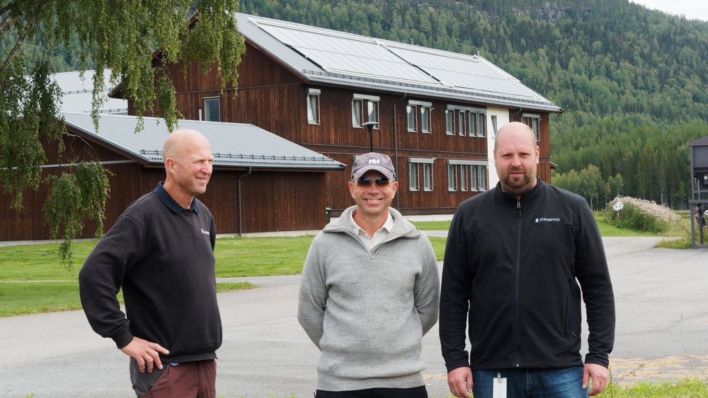 Per Anders Westgard, Ola Johansson og Martin Kolby foran et av byggene som samler varme med solfangere.