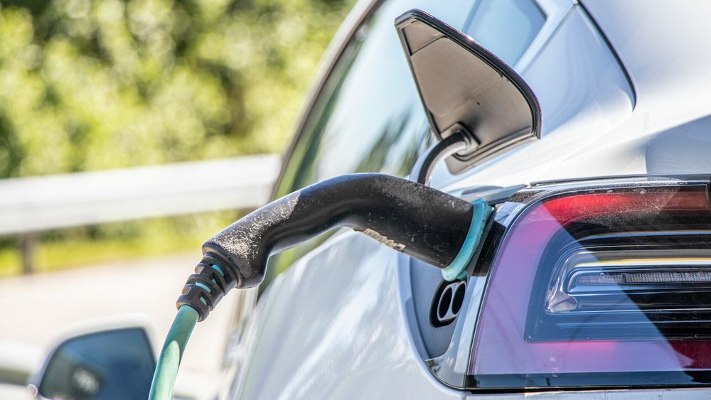 Tesla Model 3 lader med ladestasjon og Type 2-kontakt.