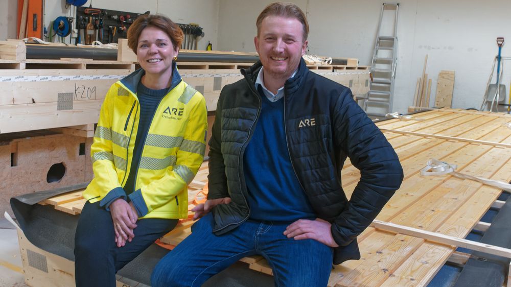 Marthe Lie og Hans Martin Andersen, sittende på et veggelement som i fremtiden kan bli levert med ferdig intallerte solcellepaneler.