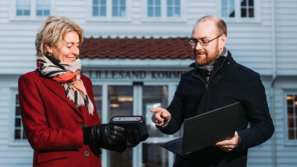 IT-sjef Andreas Brovig i Lillesand kommune viser seksjonssjef Inger Vollstad i Nkom en trygghetsalarm som er skiftet ut, da den kun går på 2G.