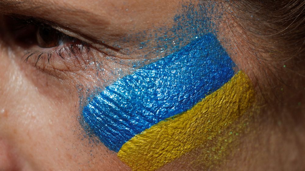 Støtten til Ukraina er stor, også i den norske IT-bransjen. Bildet viser en person som har sminket seg med et ukrainsk flagg i forbindelse med en demonstrasjon i Spania mot den russiske invasjonen av Ukraina.