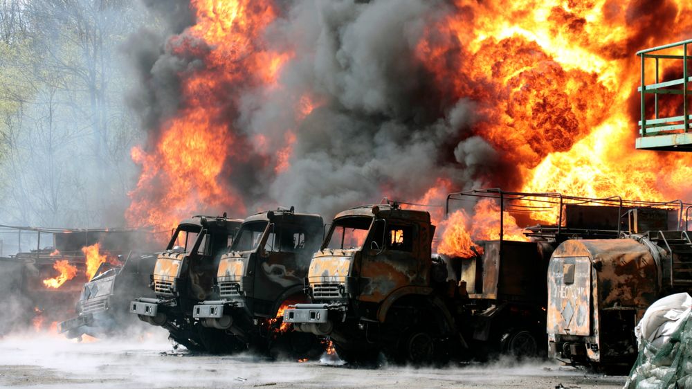 Kjøretøy står i brann ved oljelageret som ble angrepet i Makiivka onsdag.