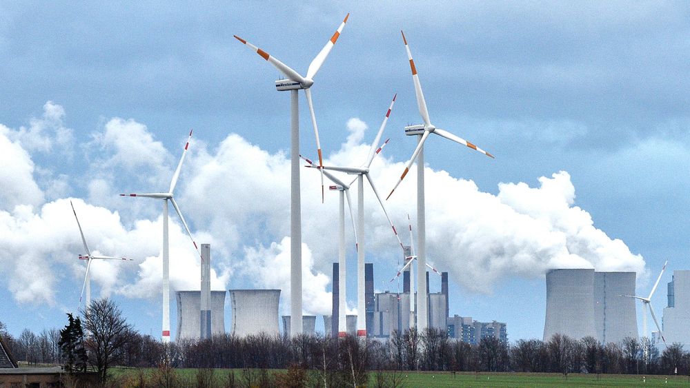 Vindturbiner foran et kullkraftverk nær Jackerath i Tyskland. De totale klimagassutslippene i EU øker igjen.