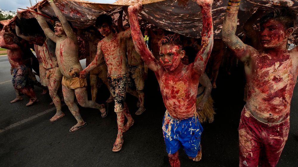 Det røde blekket på kroppene til disse demonstrantene symboliserer urfolks blod som er spilt grunnet gruvedrift på deres områder.