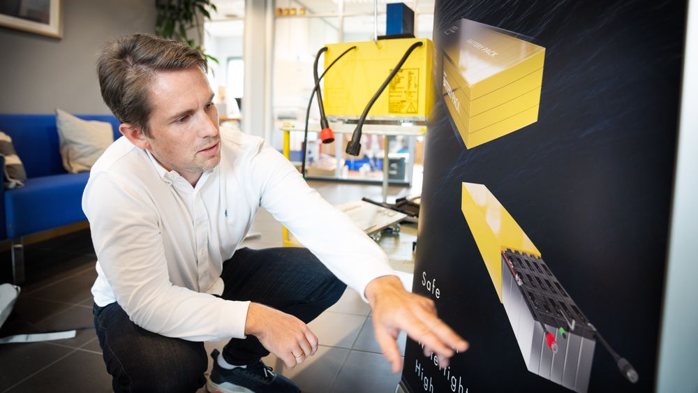 Andreas Norberg i Zen Oceans med batterimodul og plakat som viser systemet. Batteriene er basert på litium-jernfosfat-celler og vannkjøling. Batteriene er støpt inn i brannhemmende polyuretanplast.