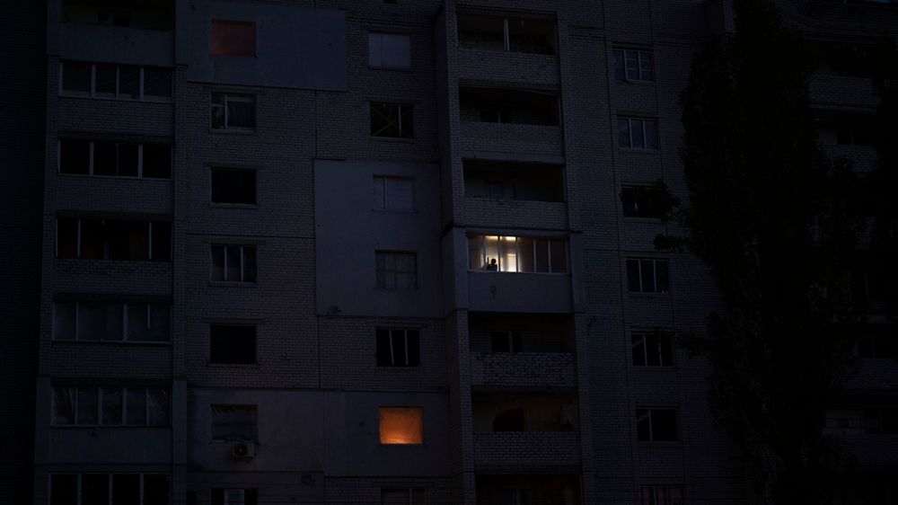 Russlands angrep mot ukrainske kraftverk har ført til omfattende strømbrudd og pålegg om strømsparing. Her ser en mann ut av et vindu i en boligblokk som er blitt ødelagt i Borodjanka i Kyiv-regionen.
