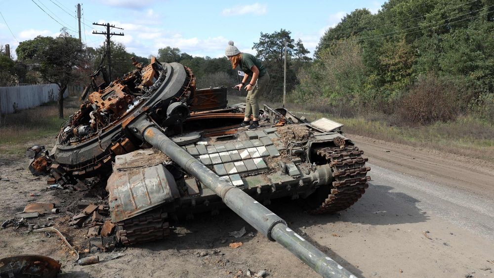 Ei jente studerer ei ødelagt russisk stridsvogn i landsbyen Oskol i Kharkiv 9. oktober.