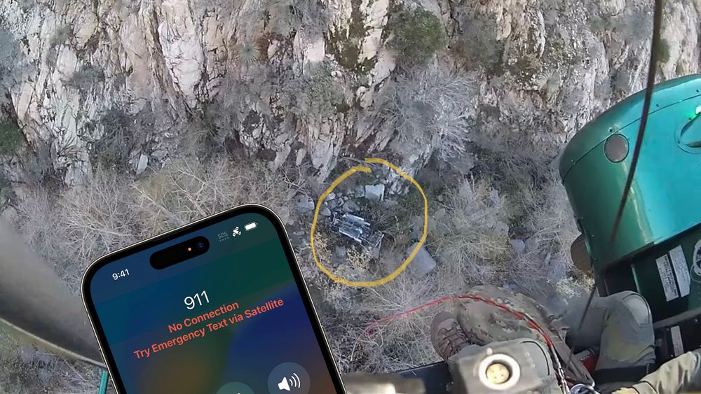 Bilvrak nede i en canyon i Los Angeles County, sett fra et redningshelikopter som har blitt varslet via satellitt av bilførerens Iphone 14. Dette kan både gjøres av brukeren selv eller utløses automatisk av en kollisjonsdetektor i mobilen.