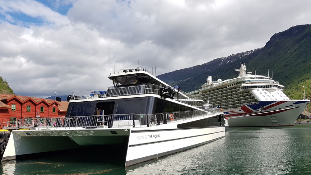 Future of the Fjords til kai i Flåm med P&O-cruiseskipet Britannia ved cruisekaia. Flåm i Auralandsfjorden, en av fem på UNESCOs liste over Verdensarvfjorder. 