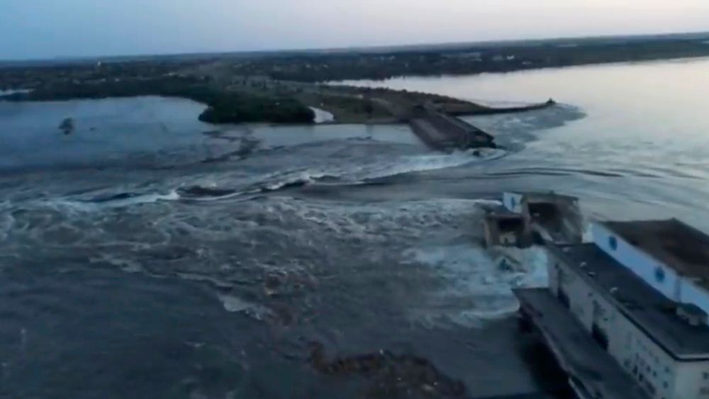 Store vannmasser fosset i morgentimene tirsdag gjennom den ødelagte Kakhovka-dammen øst i Ukraina.
