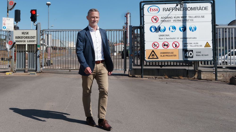 Øyvind Rudberg foran et inngangsskilt til Slagentangen som snart kan få et tillegg om produksjon av hydrogen og ammoniakk.