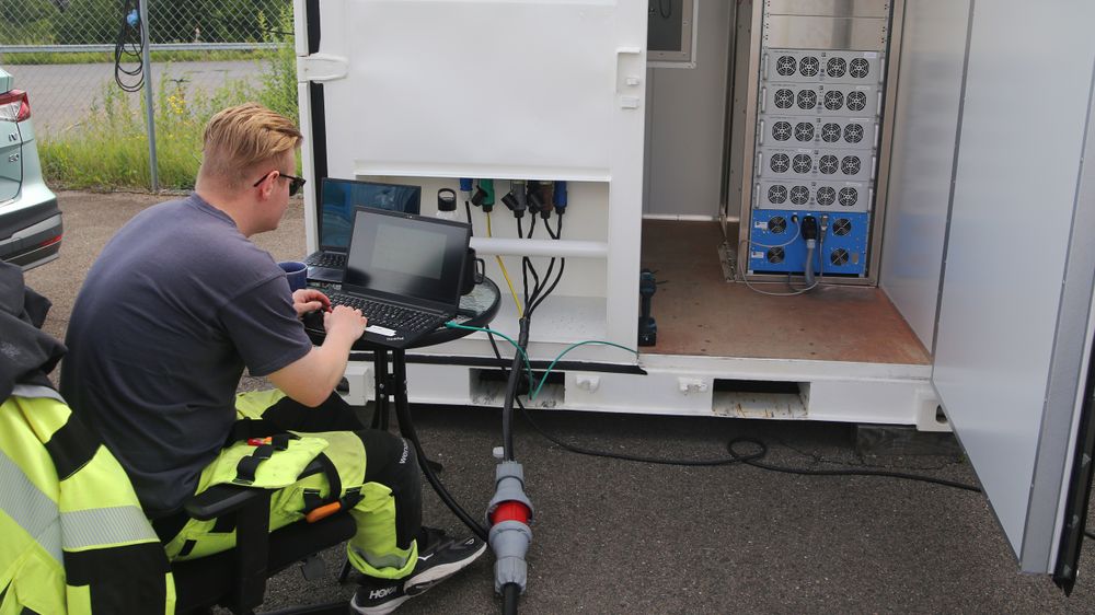 Elektrotekniker Andreas Holte tester en ny ladestasjon på kollegenes biler.