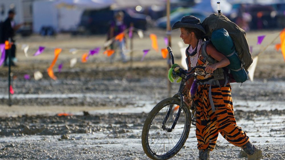 En kvinne vasser i gjørme etter regnværet som har gjort Burning Man-festivalen til en enda mer spesiell opplevelse enn normalt for de rundt 70.000 deltakerne.