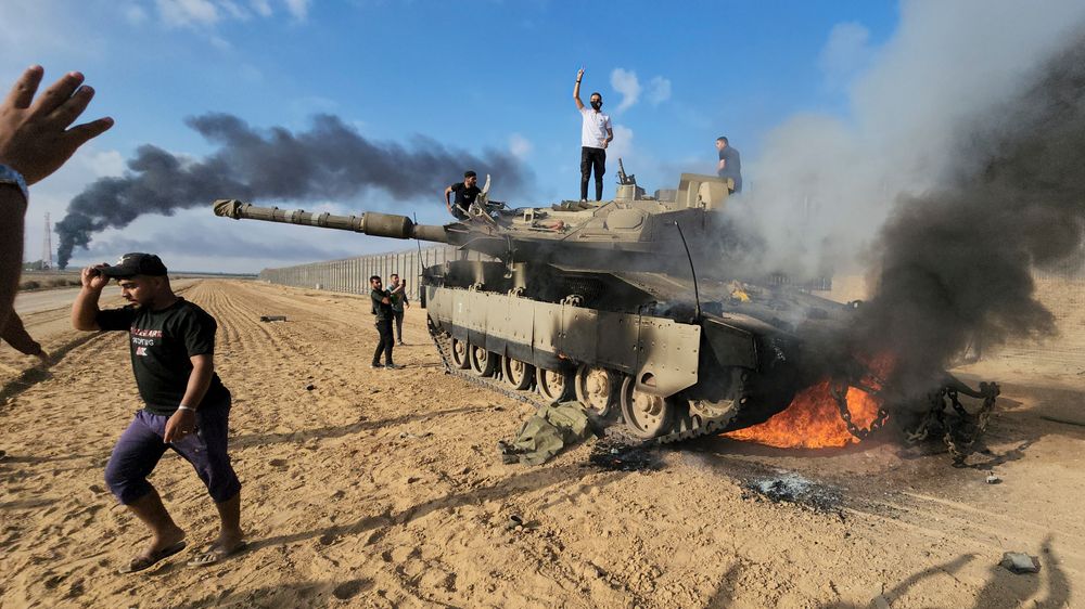 Palestinere feiret på en ødelagt israelsk stridsvogn på Gazastripen lørdag.