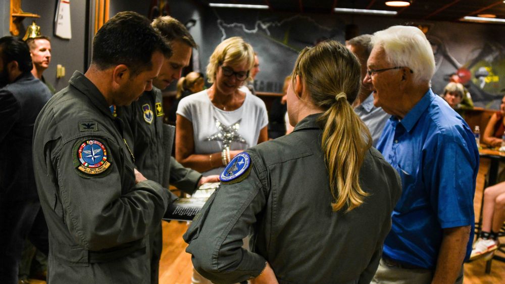 Oberst Brad Orgeron, sjef for 80th Flying Training Wing på Sheppard, mottar ei fotobok om Ankang fra bestefaren til den ferske F-35-flygeren på uteksamineringsseremonien.