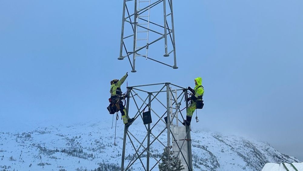 Tårnselskapets første tårn er satt opp på Flå i Hallingdal. Her tar montører fra Bjerke Nettbygg imot toppen av tårnet, som fires ned fra helikopter.
