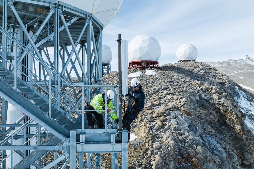 Montører i arbeid med å montere antenner for mobilnett på en antenneinstallasjon i Antarktis. 