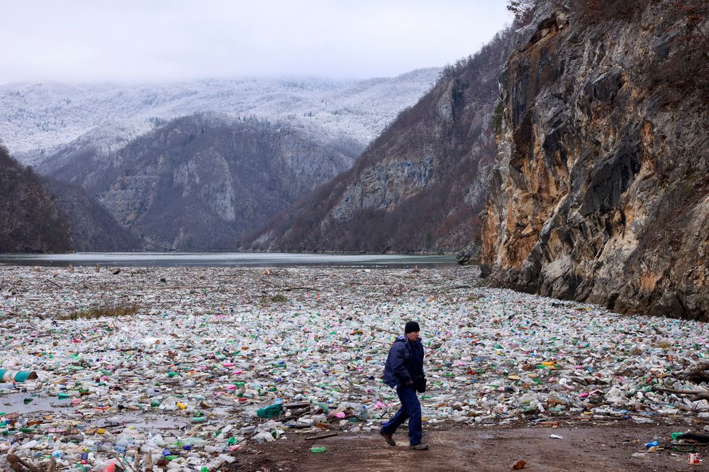 En mann passerer et stort flak med søppel elva Drina i Bosnia. Mengden søppel som produseres i verden, ventes å øke kraftig de neste tiårene.