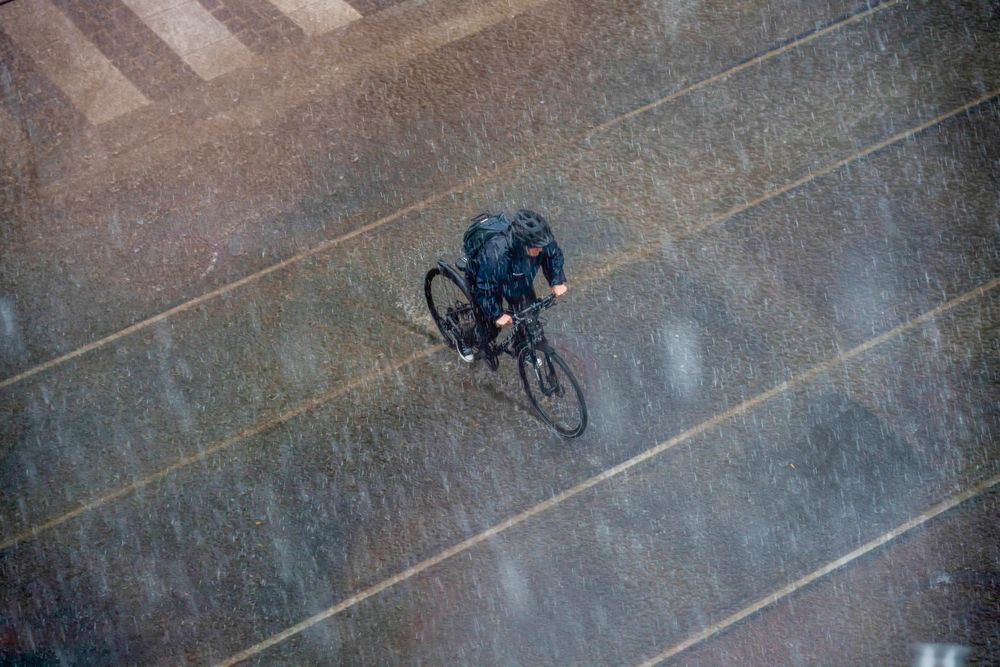 oslo, en syklist i regnværet i som falt ned over Oslo etter en lang periode med sol