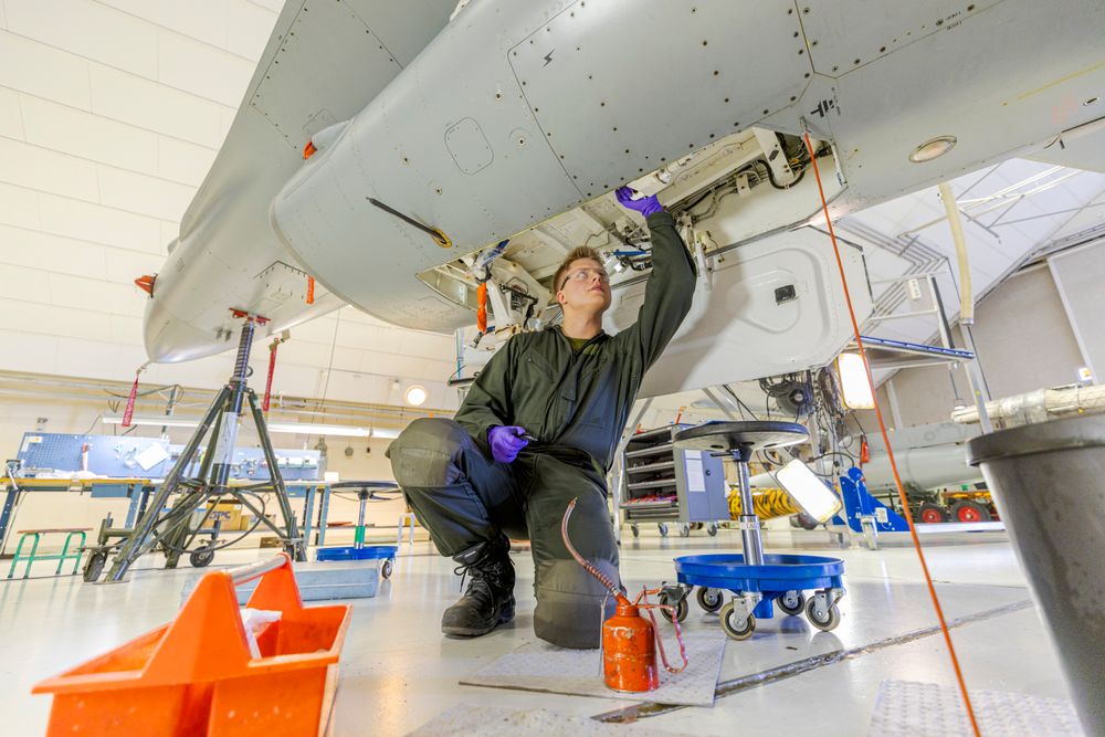 Lærlingen Vetle skrur på et gammelt F-16 fly i lærlinglaben på Ørland flystasjon. Han var da midt i fagprøven for å bli flymekaniker.