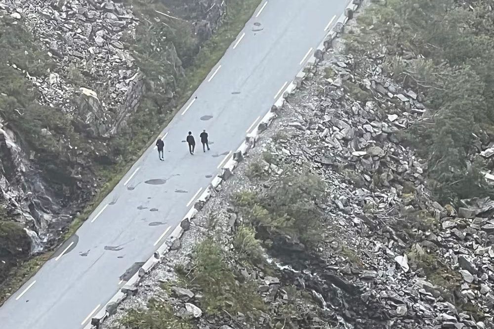 Tre personer til fots på Trollstigen i Rauma kommune lørdag 6. juli. Veien ble tidligere i sommer stengt ut året på grunn av fare for steinras.