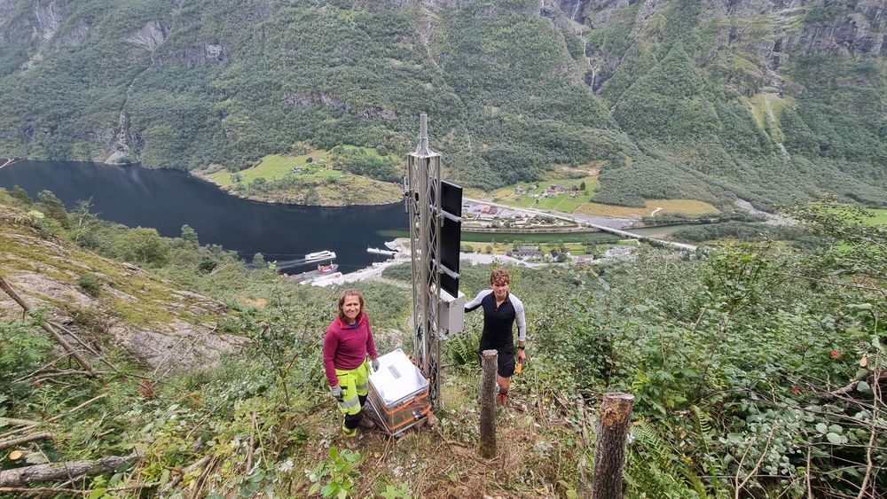 Ragnhild Lie og Torje Forstås i Cautus Geo installerer nytt utstyr i masta. Den har har solcelle og ulike kommunikasjonsløsninger som varsler hendelser, samt signalanlegg for å stenge veien.