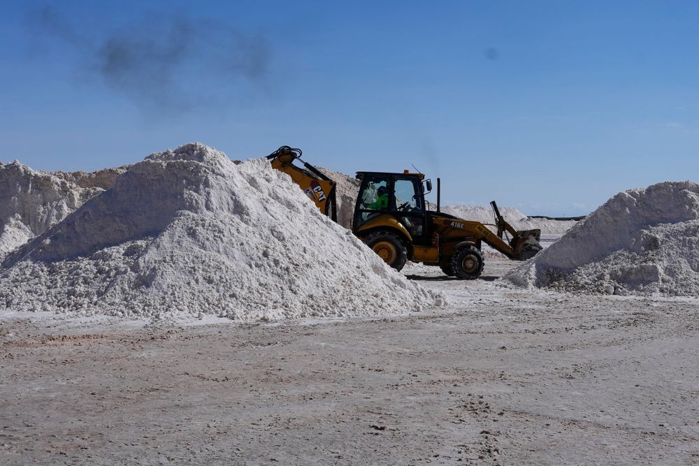 Bildet viser en arbeider som transporterer salt og som skal bearbeides på et litiumkarbonat-anlegg på saltsletten Uyuni i Bolivia.