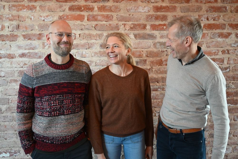 Oskar Bringager, Jorunn Tyssø og Bjørn Malm i Høine foran en vegg med ombrukt teglstein på Nansenløkka på Fornebu.