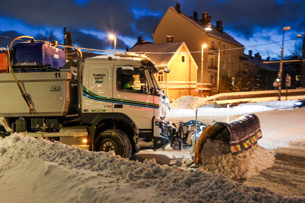 En brøytebil måker seg gjennom Trondheims snøtunge gater. 