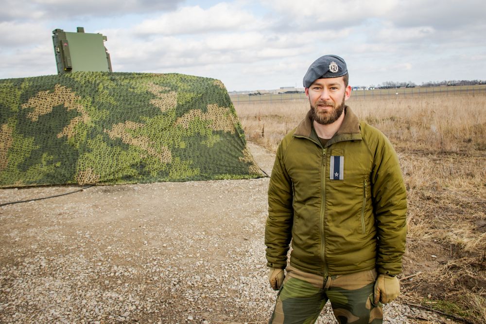 Major Steinar Larsen er sjef for det norske Nasams-batteriet ved Rzeszów-Jasionka-flyplassen i Polen. Her står han ved én av radarene til batteriet. Flyplassen og et helt annet luftvernbatteri kan skimtes i bakgrunnen.