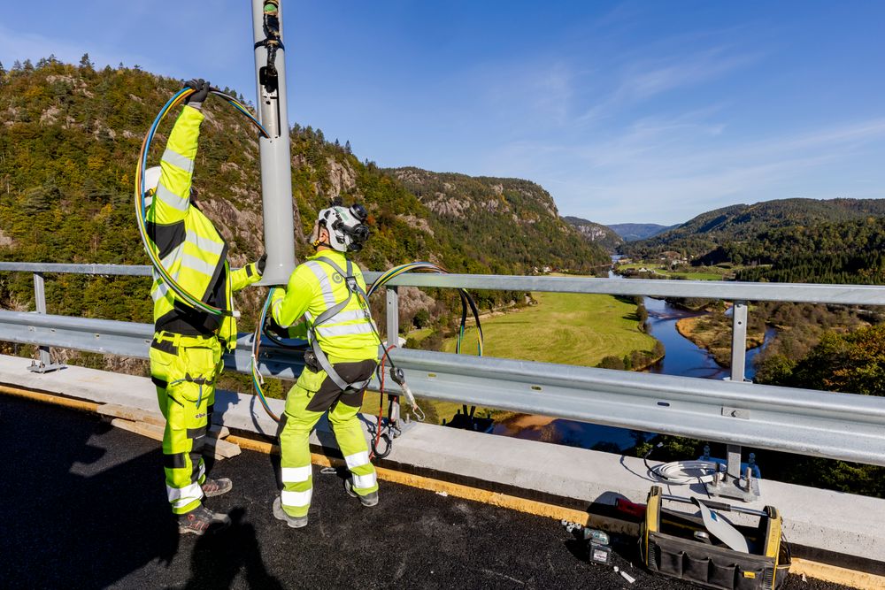 E39 nord for Lyngdal blir en del av driftskontrakten når veien åpner til sommeren. En stolpe til veilys er under montering på Kvellandsbrua i oktober i fjor. Fv. Marek Pawlowski og Lukas Skotnicki.