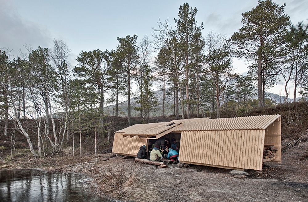 Dette er Heggmoen Campsite. Oppgaven fra Bodø friluftsavdeling var å lage et bygg som ga beskyttelse mot vær og vind og samtidig ga utsikt til naturen omkring og slapp inn dagslys i «tilfluktsrommet». Heggmoen er et badested med sandstrender, der det grunne elvevannet blir ganske varmt om sommeren. Men resten av året er klimaet arktisk og røft.