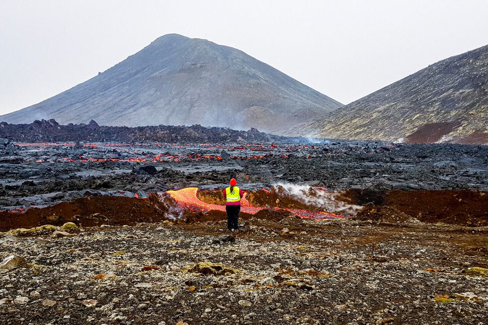 Vulkanen Fagradalsfjall var aktiv fra mars til september 2021. NTNU-professor Fjóla Guðrun Sigtryggsdóttir studerer lava som hadde begynt å strømme over en jordvoll nær en av demningene i det unike feltforsøket som startet i mai.