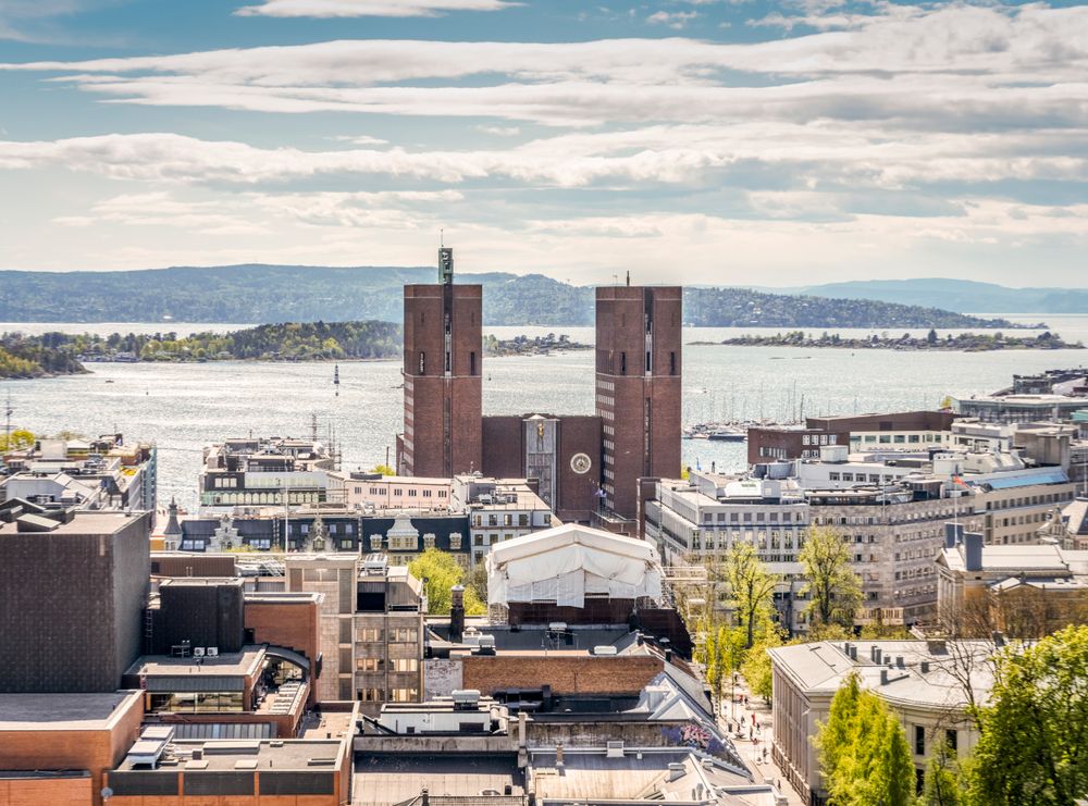 Oslo rådhus og Oslo sentrum en lys vårdag i mai. Byrådet har vedtatt å legge ned Oslo Origo, som er kommunes felles satsing på digital transformasjon. De vil samtidig opprette en ny digitaliseringsetat.