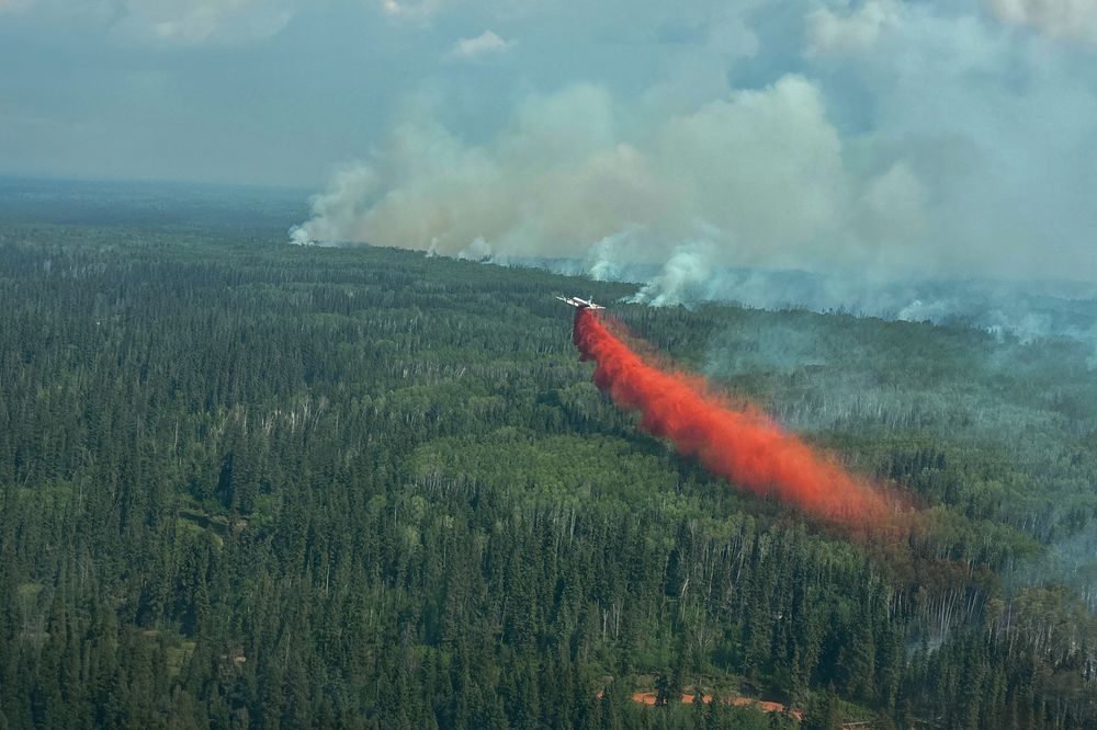 Vårens skogbranner i Canada er voldsommere enn vanlig, og noe av røyken når helt til Europa.På bildet slippes brannhemmende væske ut over brannen ved Sousa Creek i Alberta.
