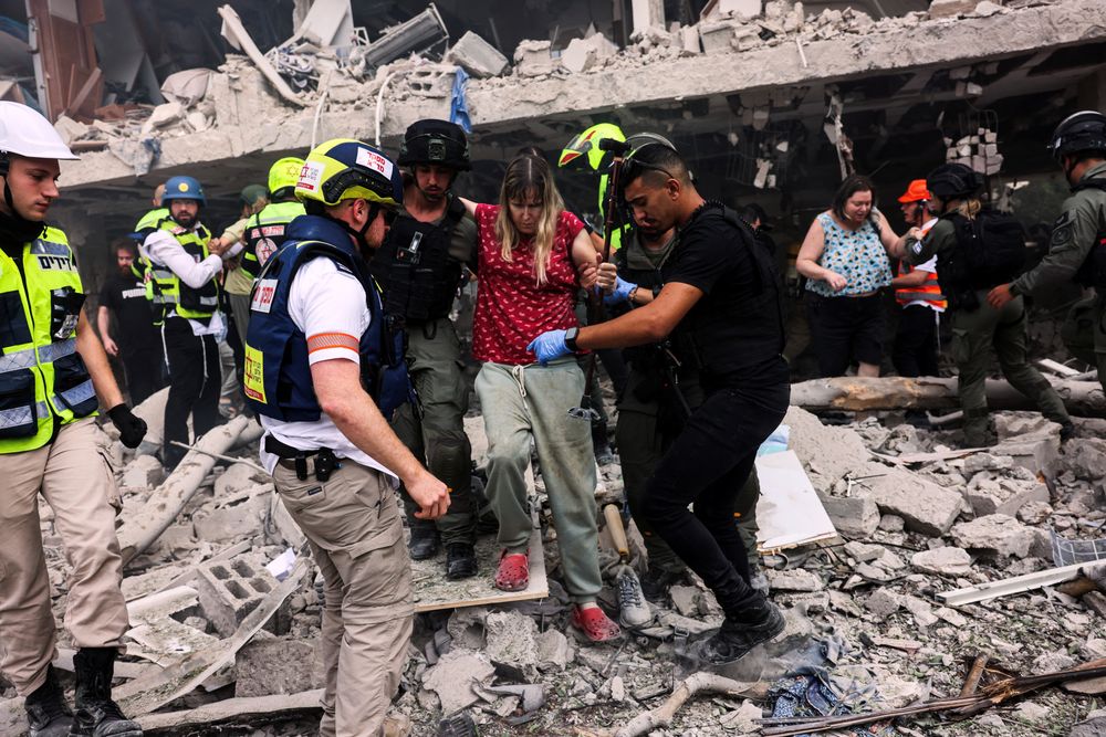 Redningspersonell evakuerer beboere fra et område i Tel Aviv etter rakettangrep fra Iran.