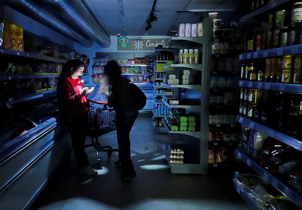 En butikkansatt i Barcelona måtte frem med lommelykten for å hjelpe en kunde under strømbruddet i Spania tidligere i år.