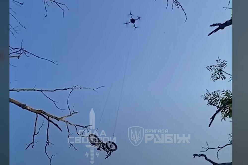 Her blir el-sykkelen senket ned til den strandede soldaten fra en relativt stor drone.