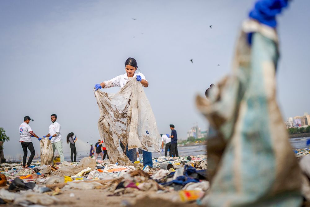 Her rydder folk plast på en strand i Mumbai i India. I 2023 ble det produsert 413,8 megatonn plast 