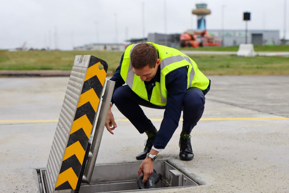 Klima- og miljøminister Andreas Bjelland Eriksen med den nye elflyladeren på Stavanger lufthavn.