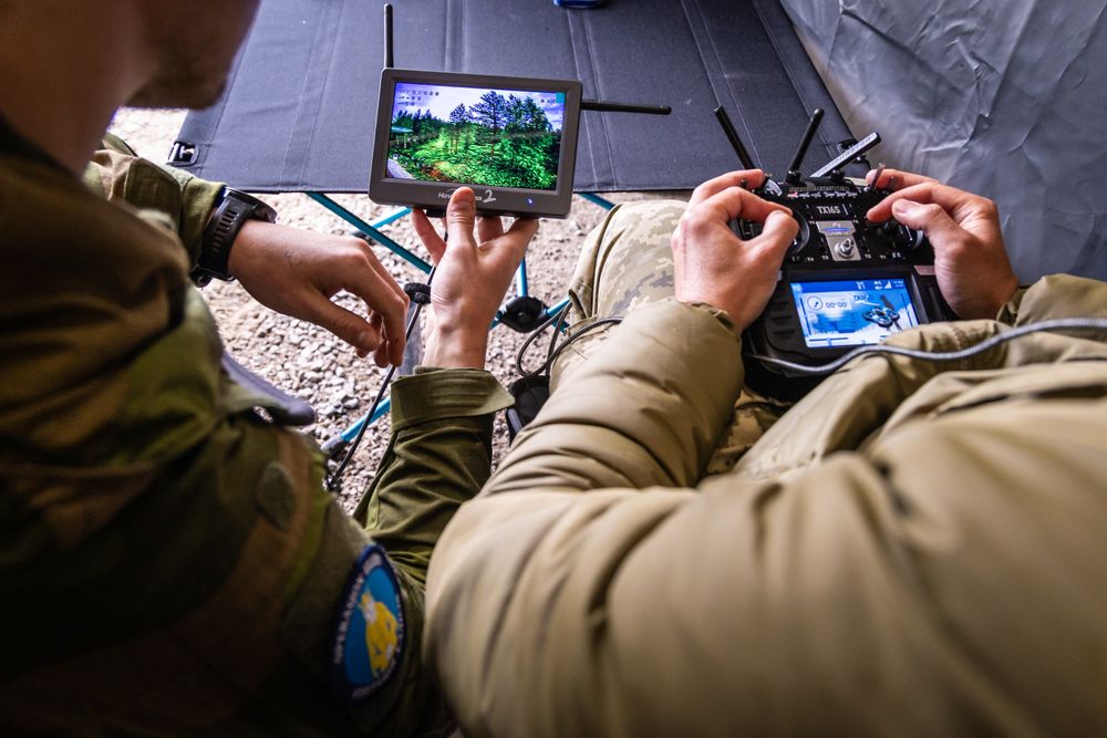 En norsk instruktør følger med på skjermen om hvor og hvordan en ukrainer flyr med drone under et droneoperatørkurs i operasjon Gungne tidligere i år.