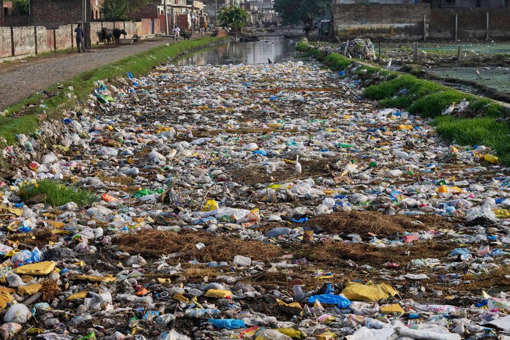 Avfallsmaterialer, hovedsakelig plast, flyter på et dreneringsanlegg i Lahore, Pakistan.