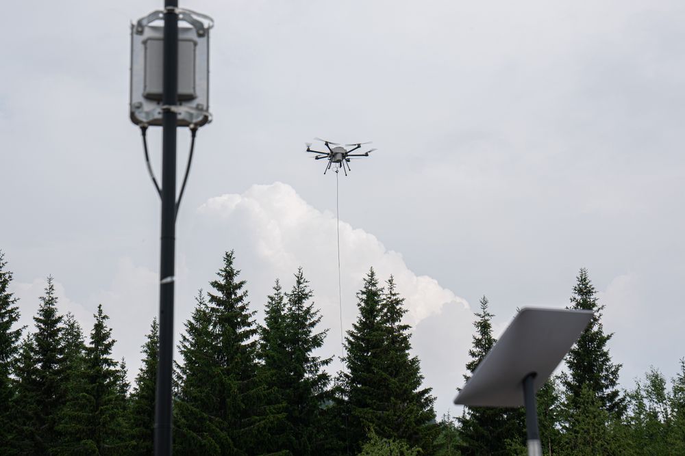 Forsvaret har testet forlengelse av mobilnettet i felt. Her en test sammen med Telia der dronen ble brukt som flyvende mobilantenne, og matet basestasjonen i forgrunnen med signaler fra Telias ordinære basestasjon en liten mil unna. Nederst skimtes en Starlink-antenne.