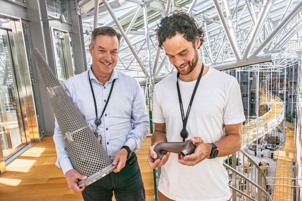 Brede Lærum (t.v.), som er sjef for 3D-print i Equinor, og 3D–print-ekspert Kristoffer Haugland viser frem to deler Equinor har fått 3D-printet. Det sparte dem for både tid og penger. Nå går selskapet i bresjen for å digitalisere varelageret i bransjen. Kjeglen er et printet filter.